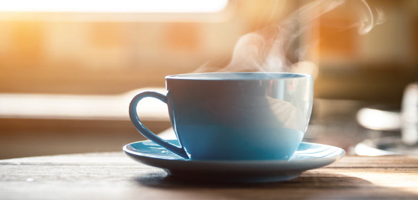 Tasse de cafe fumante posee sur une table en bois