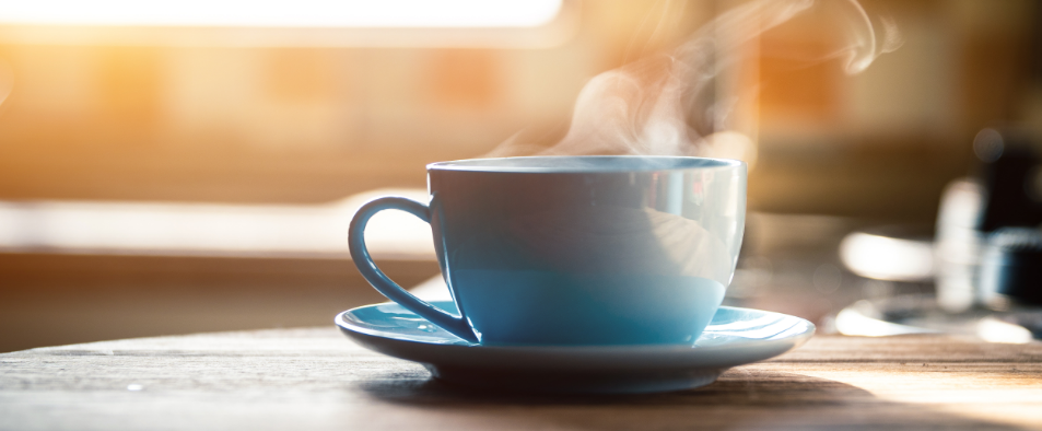 Tasse de cafe fumante posee sur une table en bois