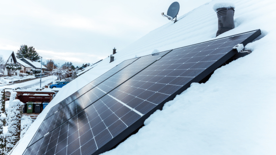 De la neige a cote de panneaux solaires poses sur un toit
